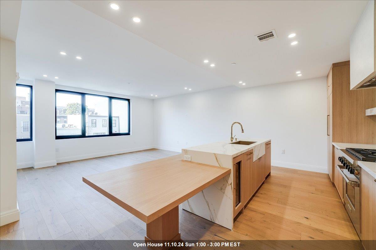 a view of kitchen with stainless steel appliances granite countertop a sink and a stove