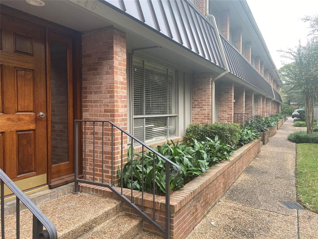 a view of brick house with potted plants