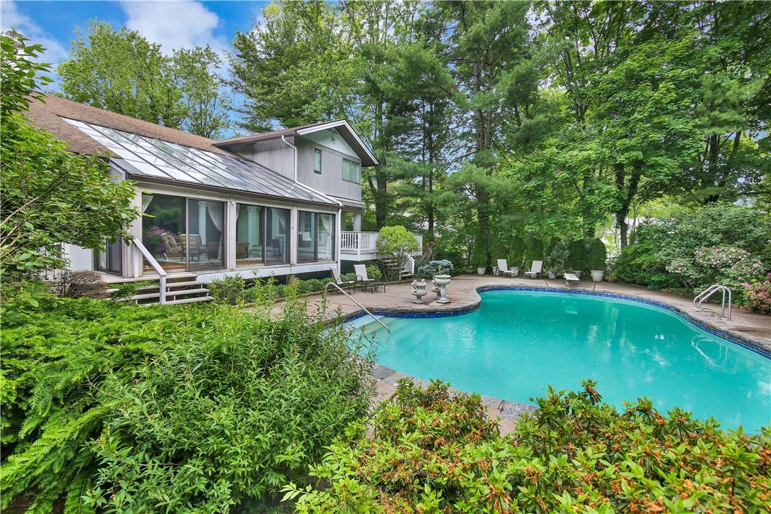 a view of a house with backyard patio and swimming pool