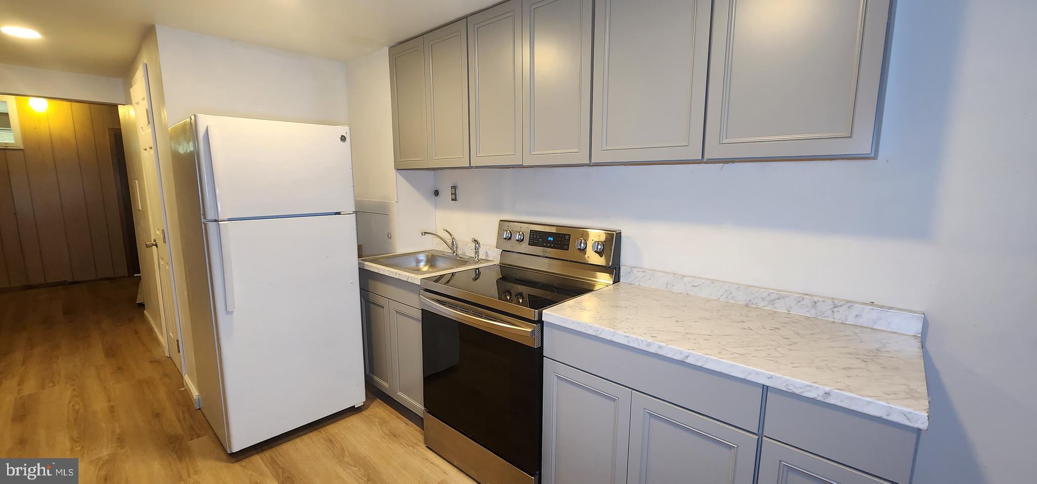 a kitchen with a refrigerator sink and cabinets