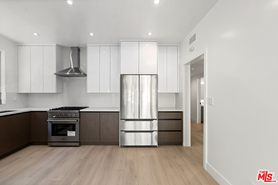 a kitchen with stainless steel appliances granite countertop a refrigerator and a stove top oven