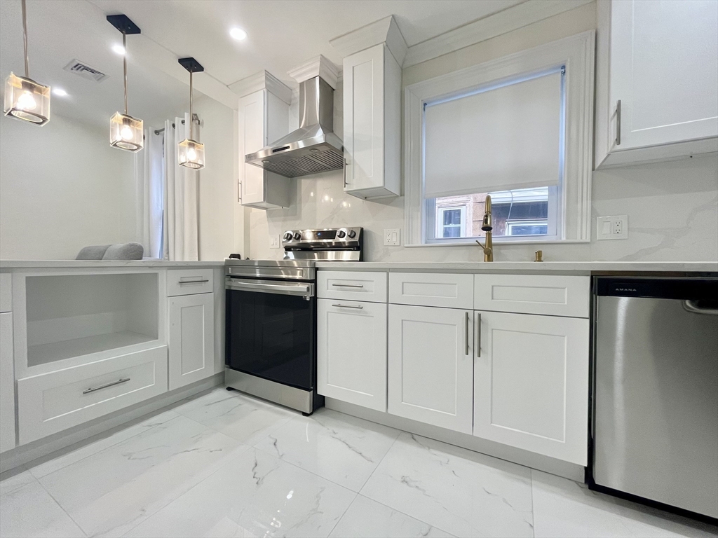 a kitchen with white cabinets and appliances