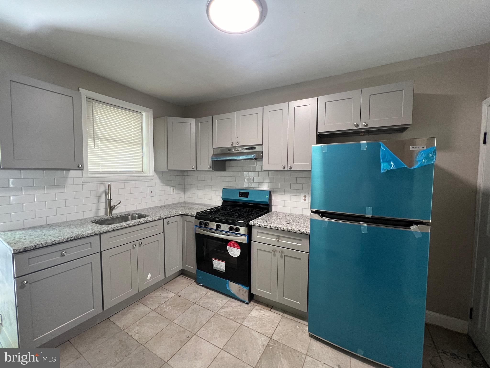 a kitchen with stainless steel appliances granite countertop a refrigerator sink and stove