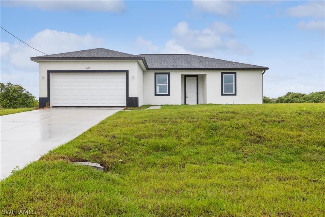 a front view of a house with yard and garage