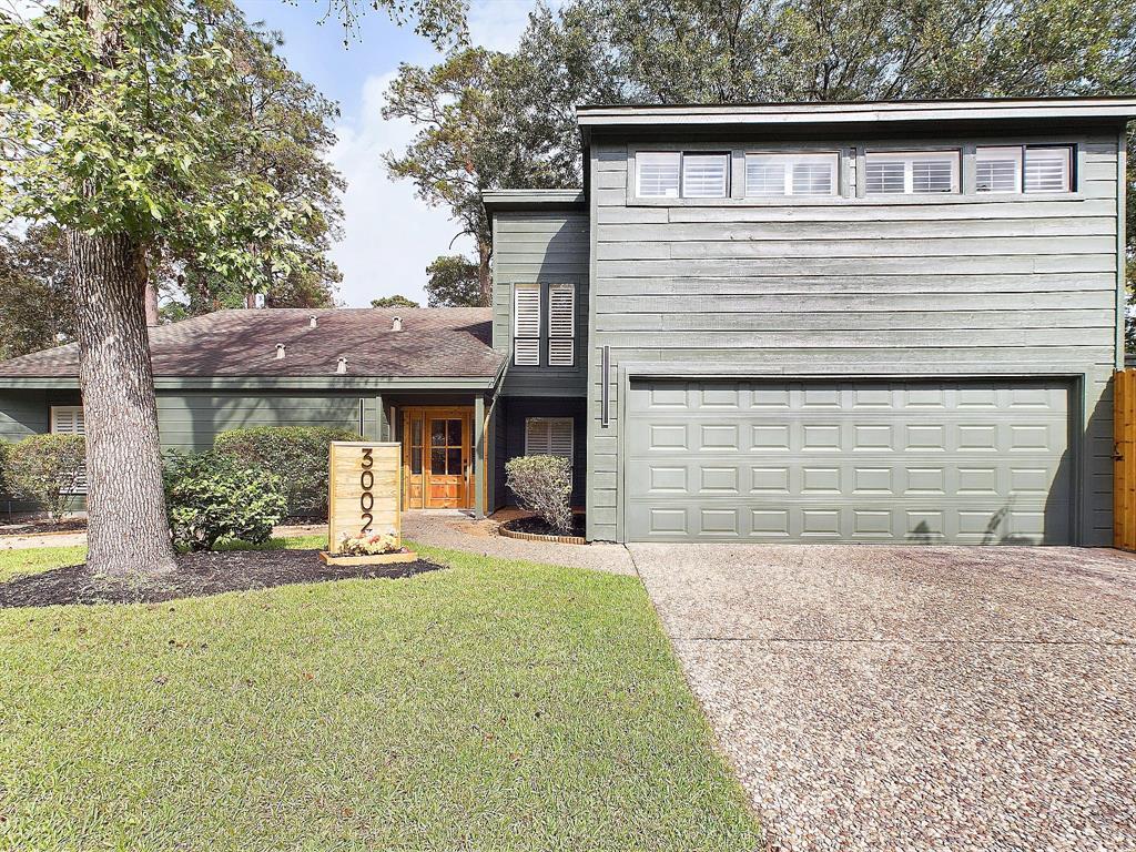 a front view of a house with a yard and potted plants