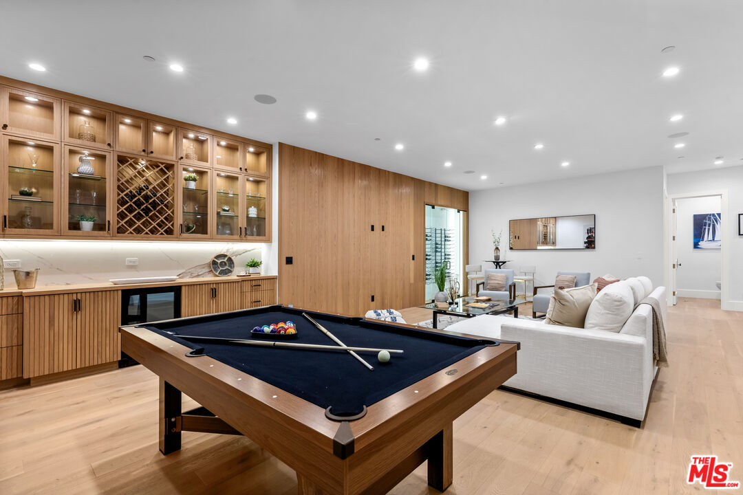 a living room with stainless steel appliances furniture and wooden floor