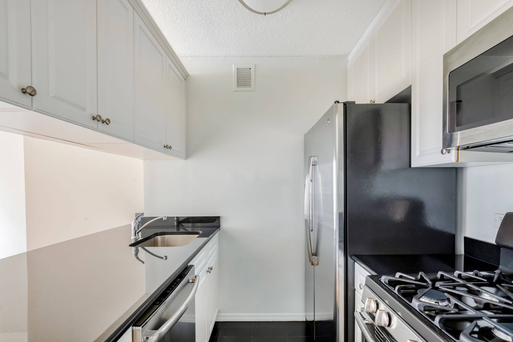 a kitchen with stainless steel appliances a refrigerator and a stove top oven