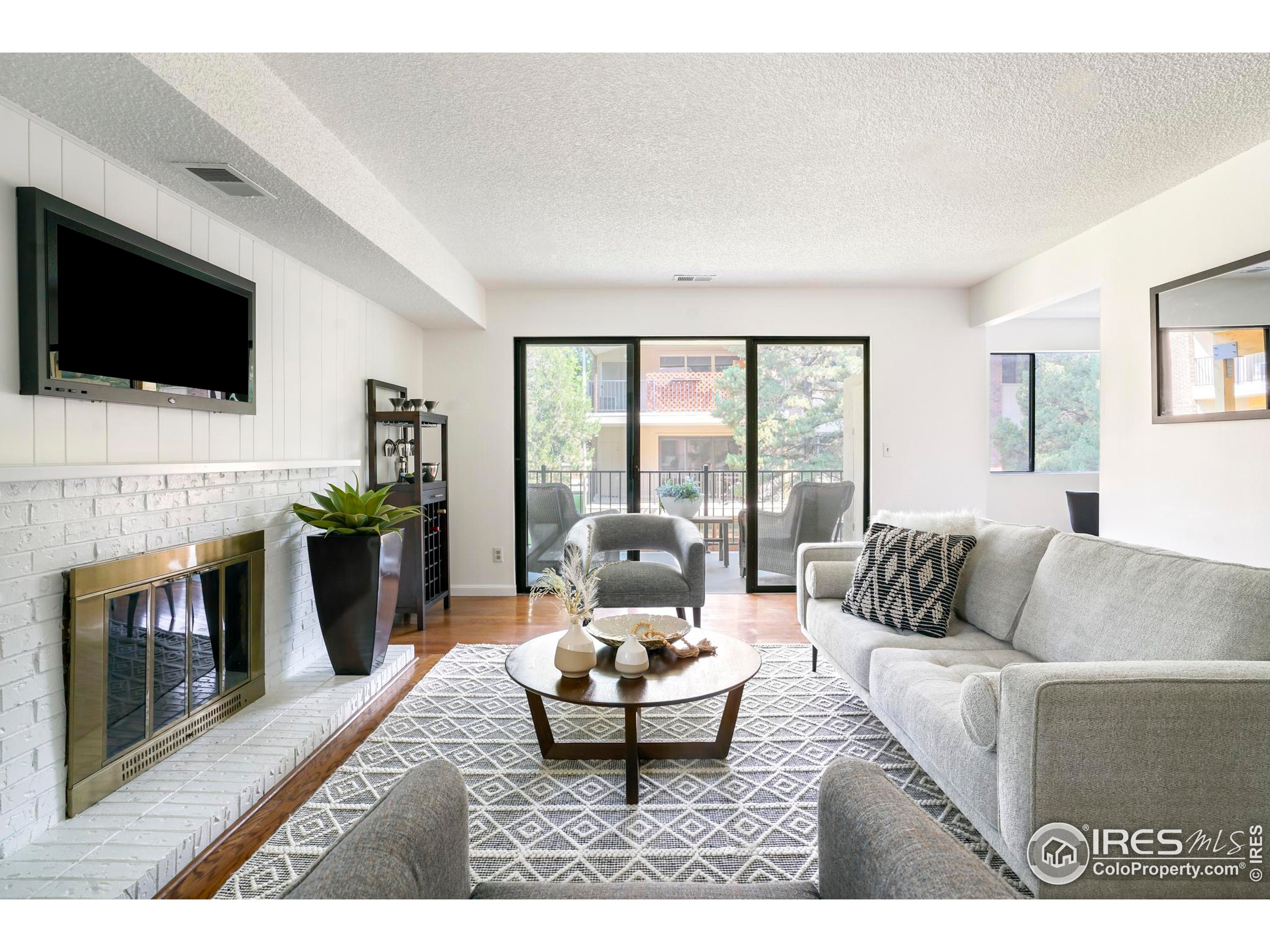 a living room with furniture a flat screen tv and a fireplace