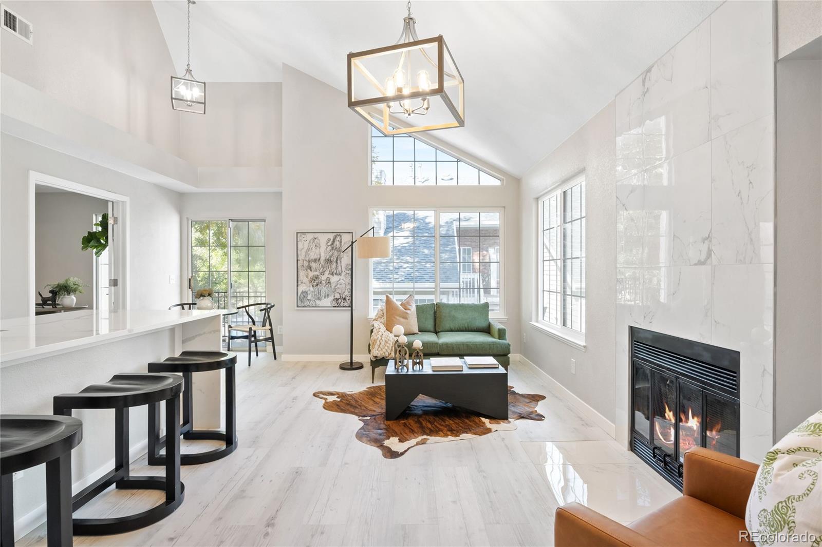 a living room with furniture large window and wooden floor