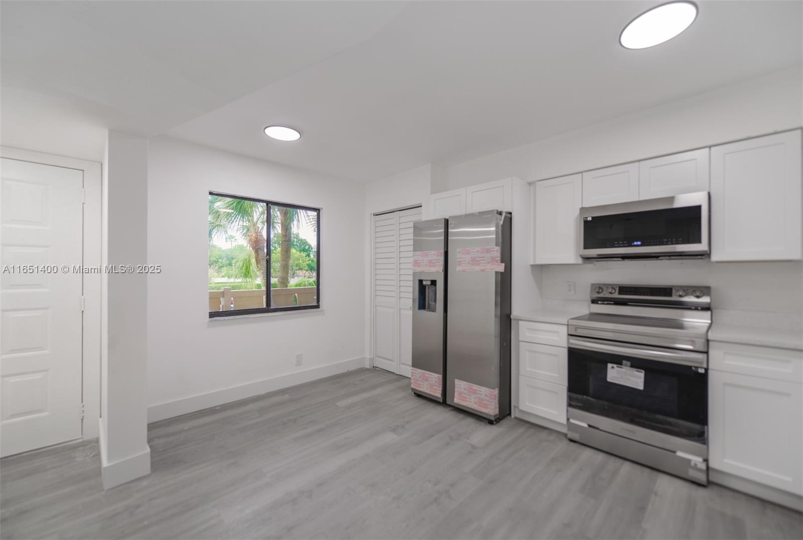 a view of a kitchen with a sink a refrigerator and window