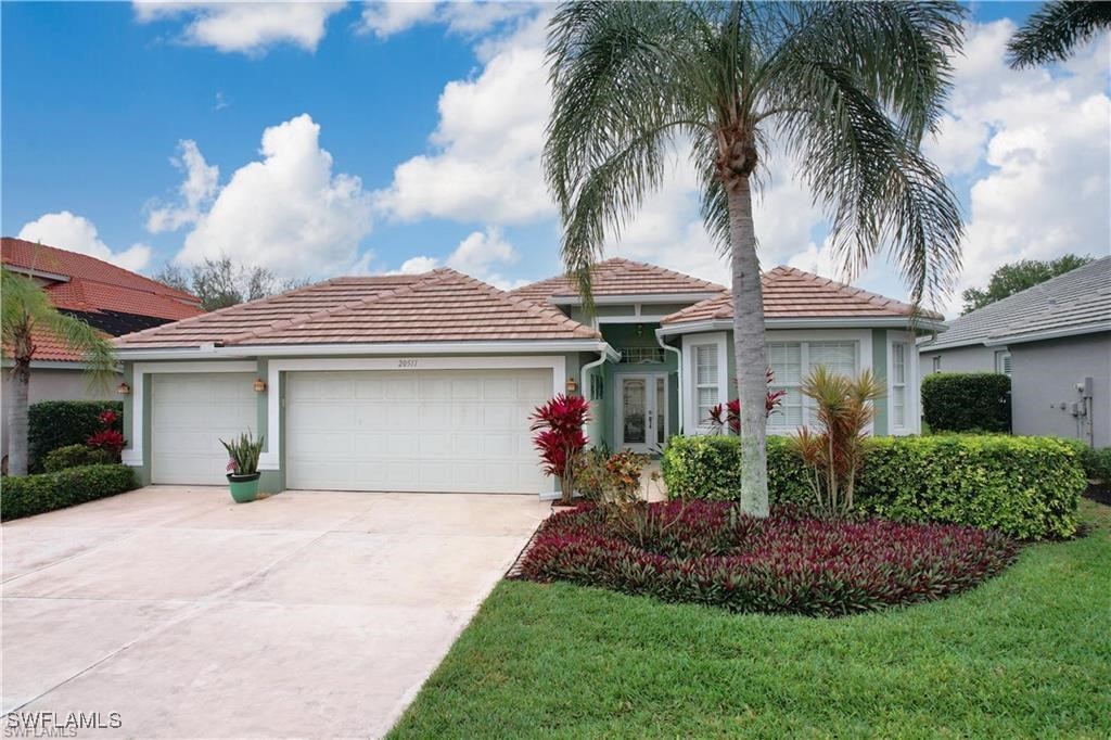 a front view of a house with a garden and yard