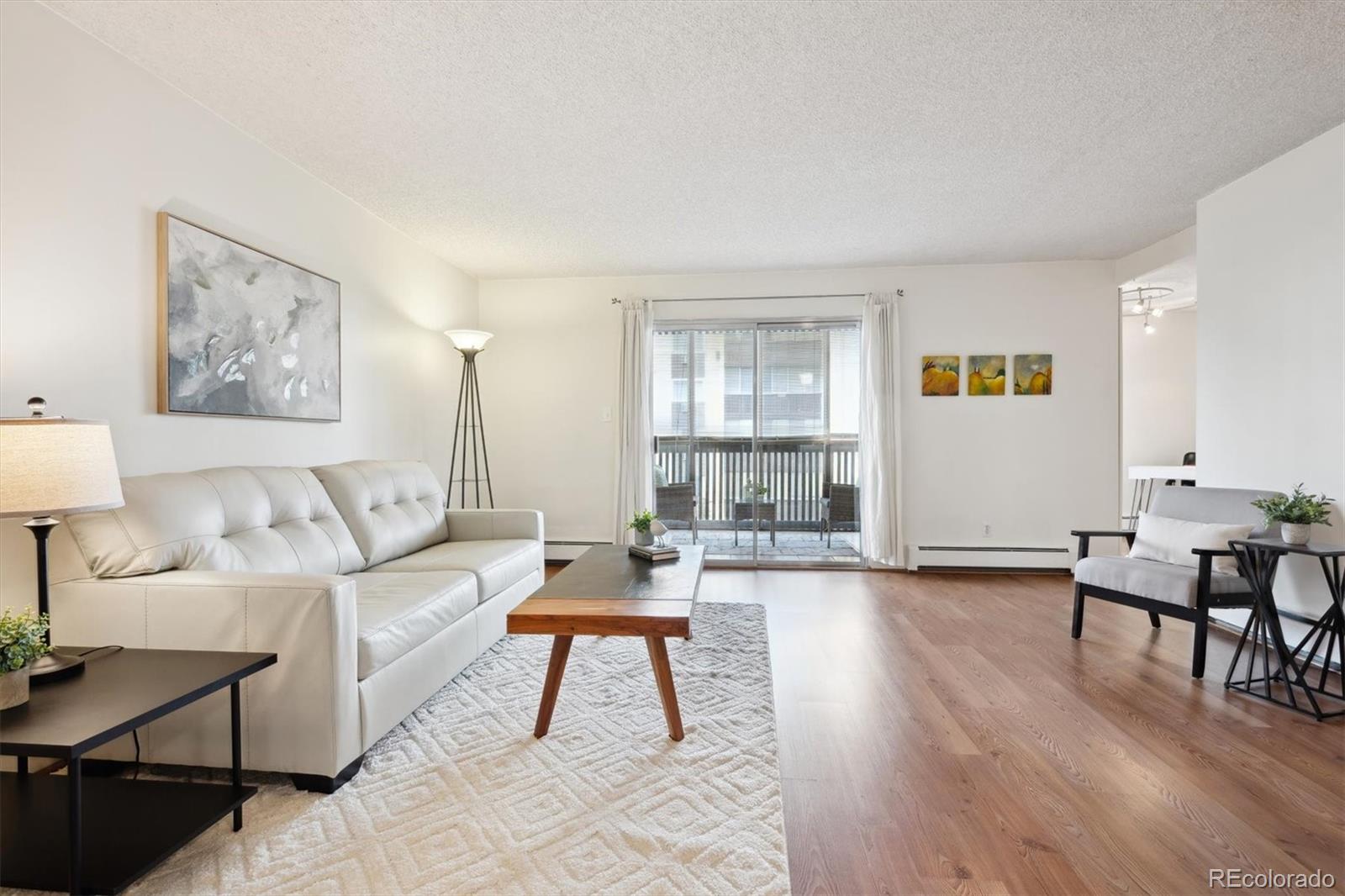 a living room with furniture and a wooden floor