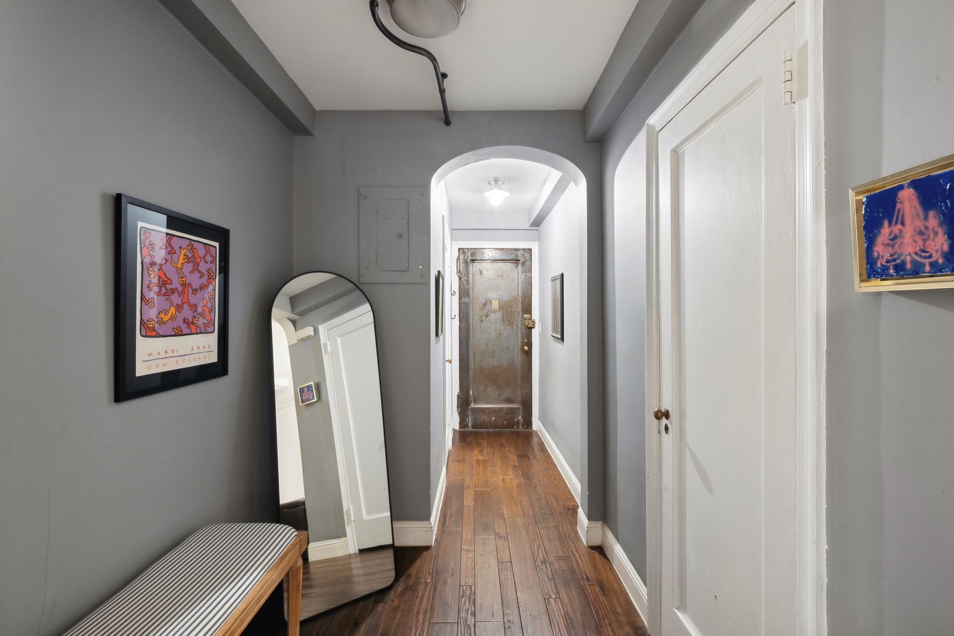 a view of a hallway with wooden floor and a potted plant