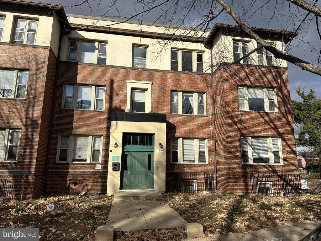 a view of a brick building next to a yard