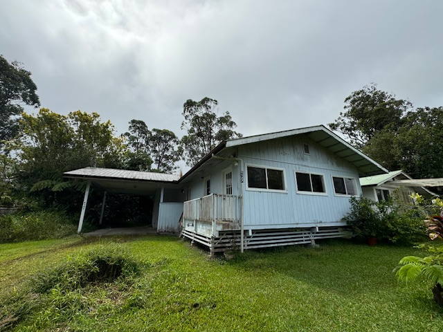 a front view of a house with a garden and trees