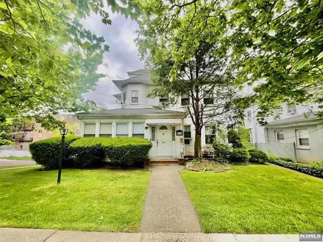 a front view of a house with a yard and a garden