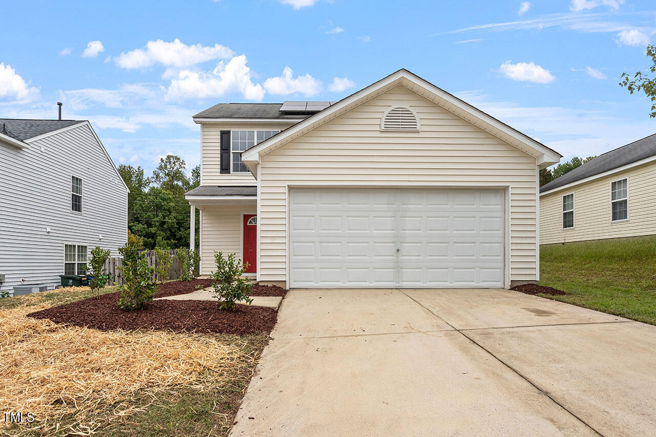 a front view of a house with a yard and garage