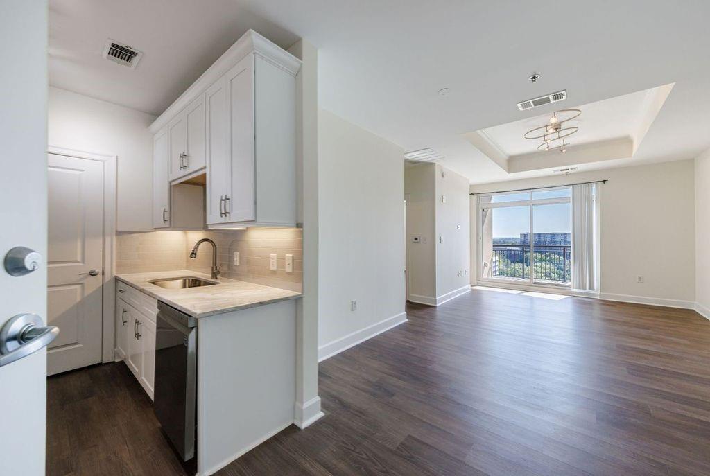 a kitchen with a sink cabinets and wooden floor