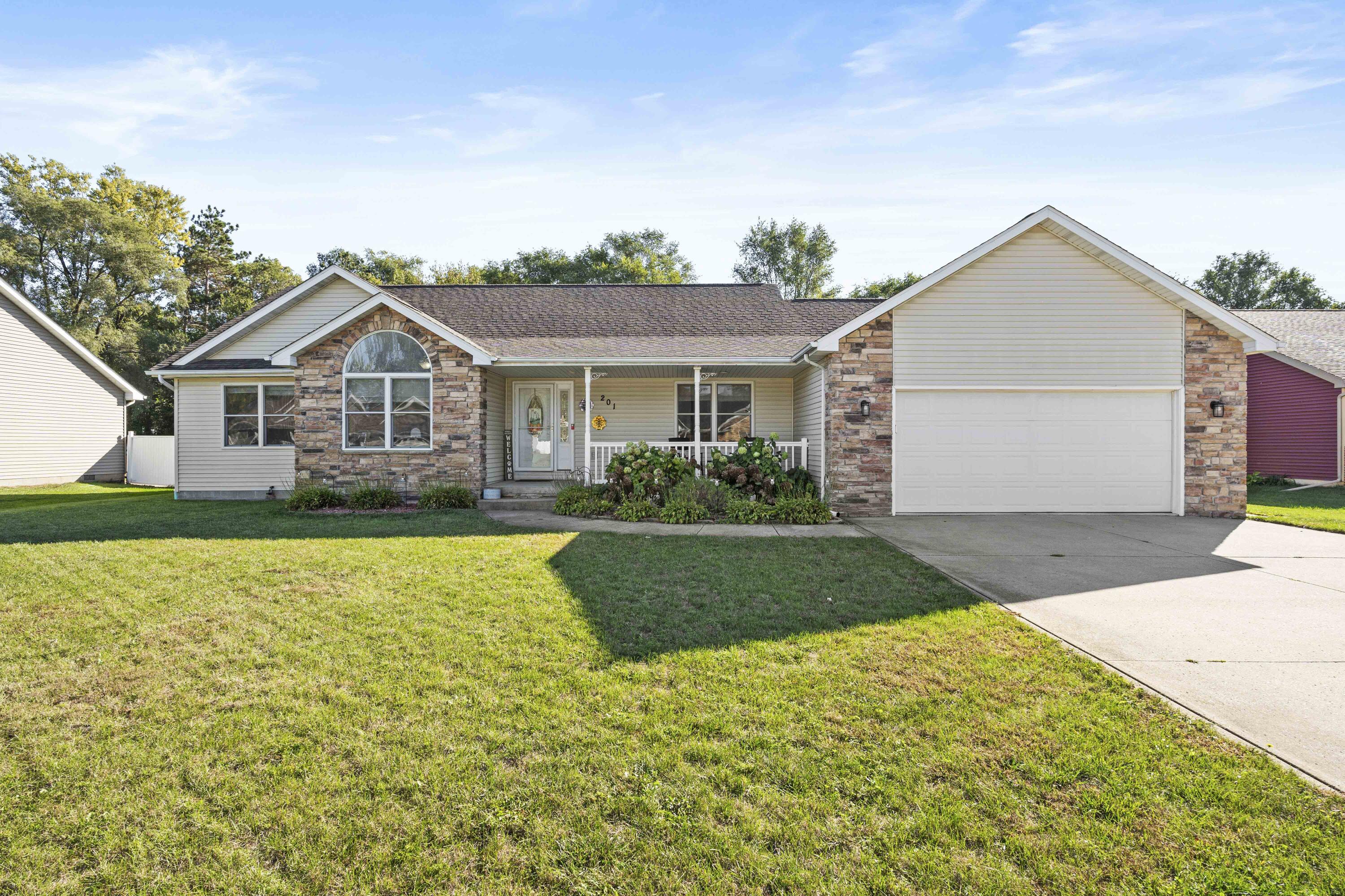 a front view of a house with a yard and garage