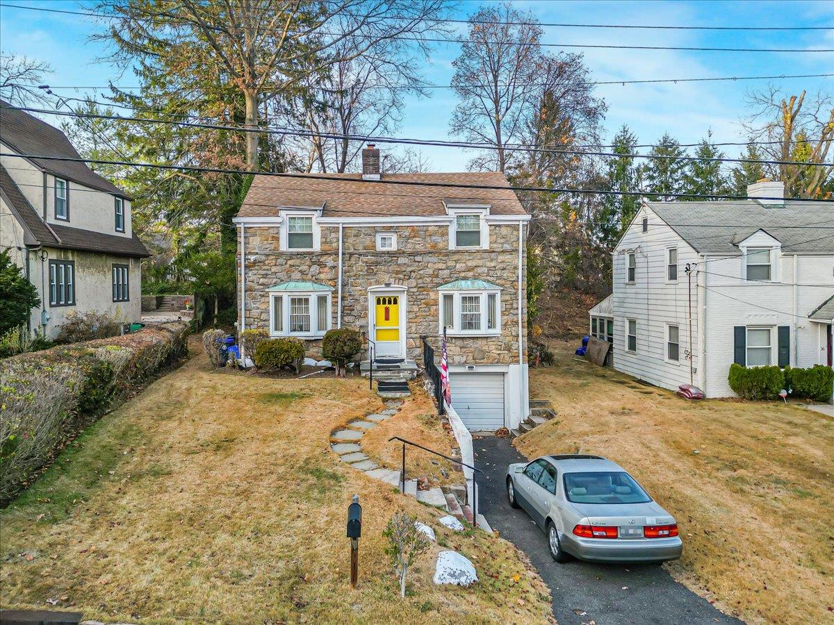 a front view of a house with cars parked