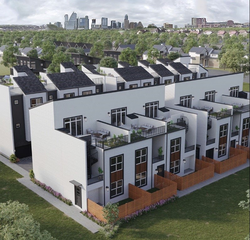 an aerial view of multiple houses with a big yard