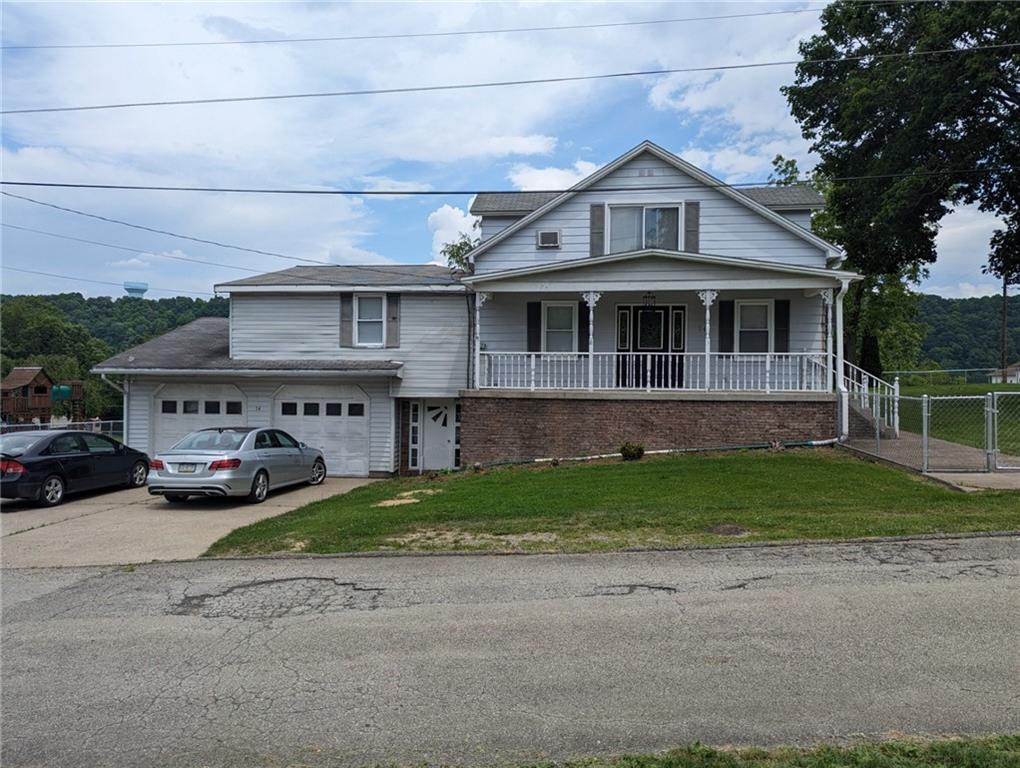 a front view of a house with a garden and parking space