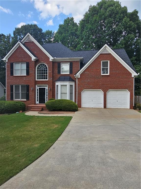 a front view of a house with a yard and garage