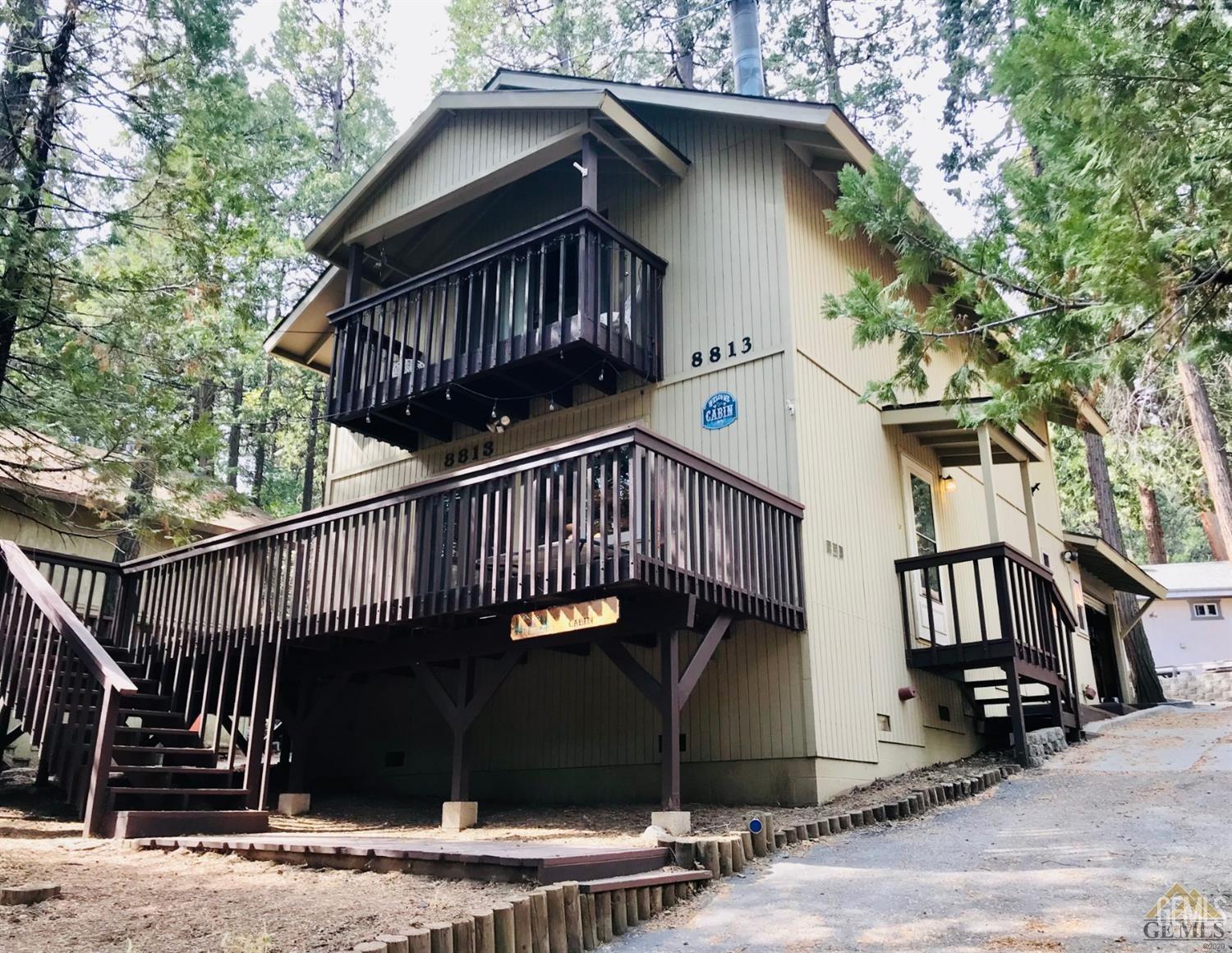 a view of a house with wooden deck front of house