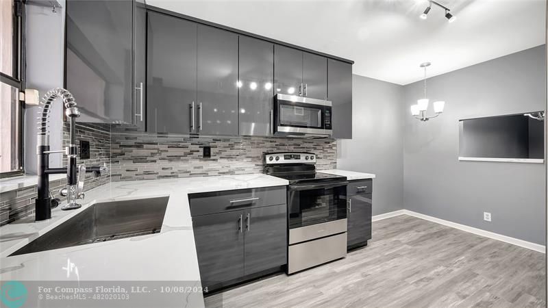 a kitchen that has a sink and a stove in it