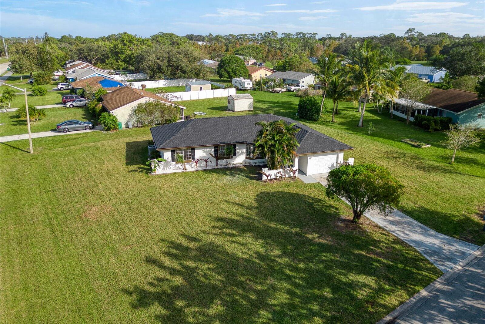 an aerial view of residential houses with outdoor space and trees