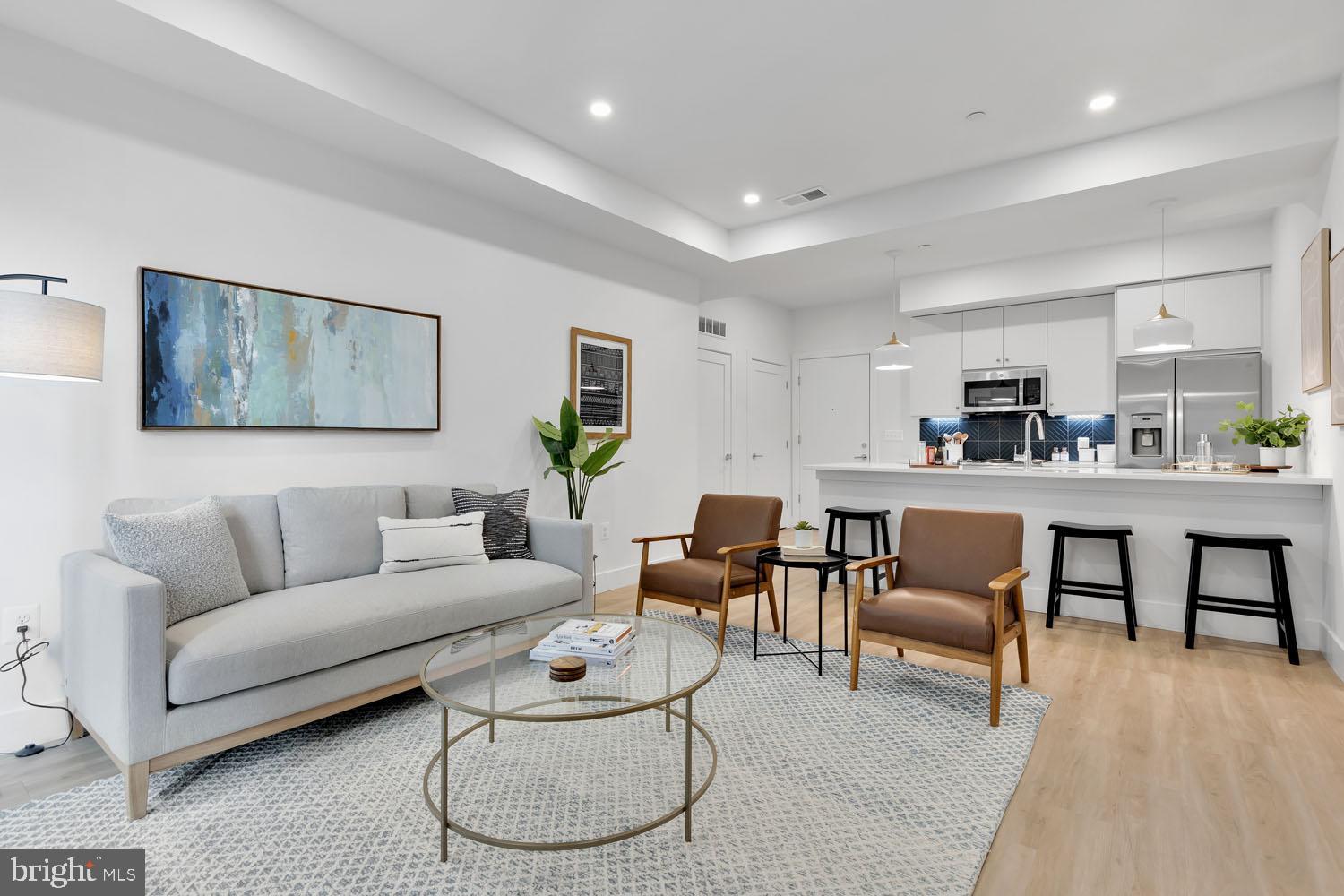 a living room with furniture and kitchen view