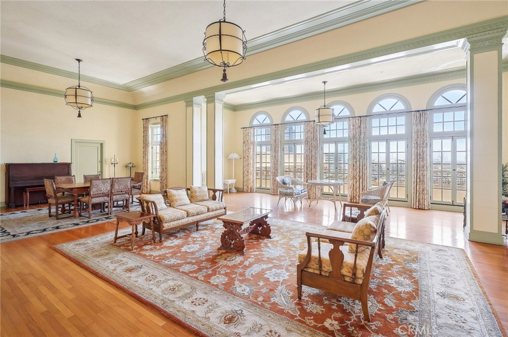 a living room with furniture large window and wooden floor