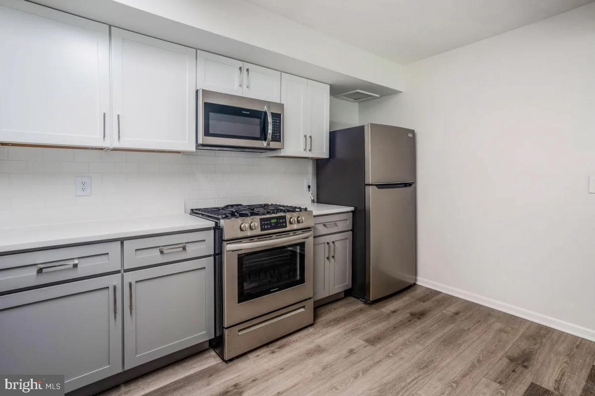 a kitchen with granite countertop white cabinets and stainless steel appliances