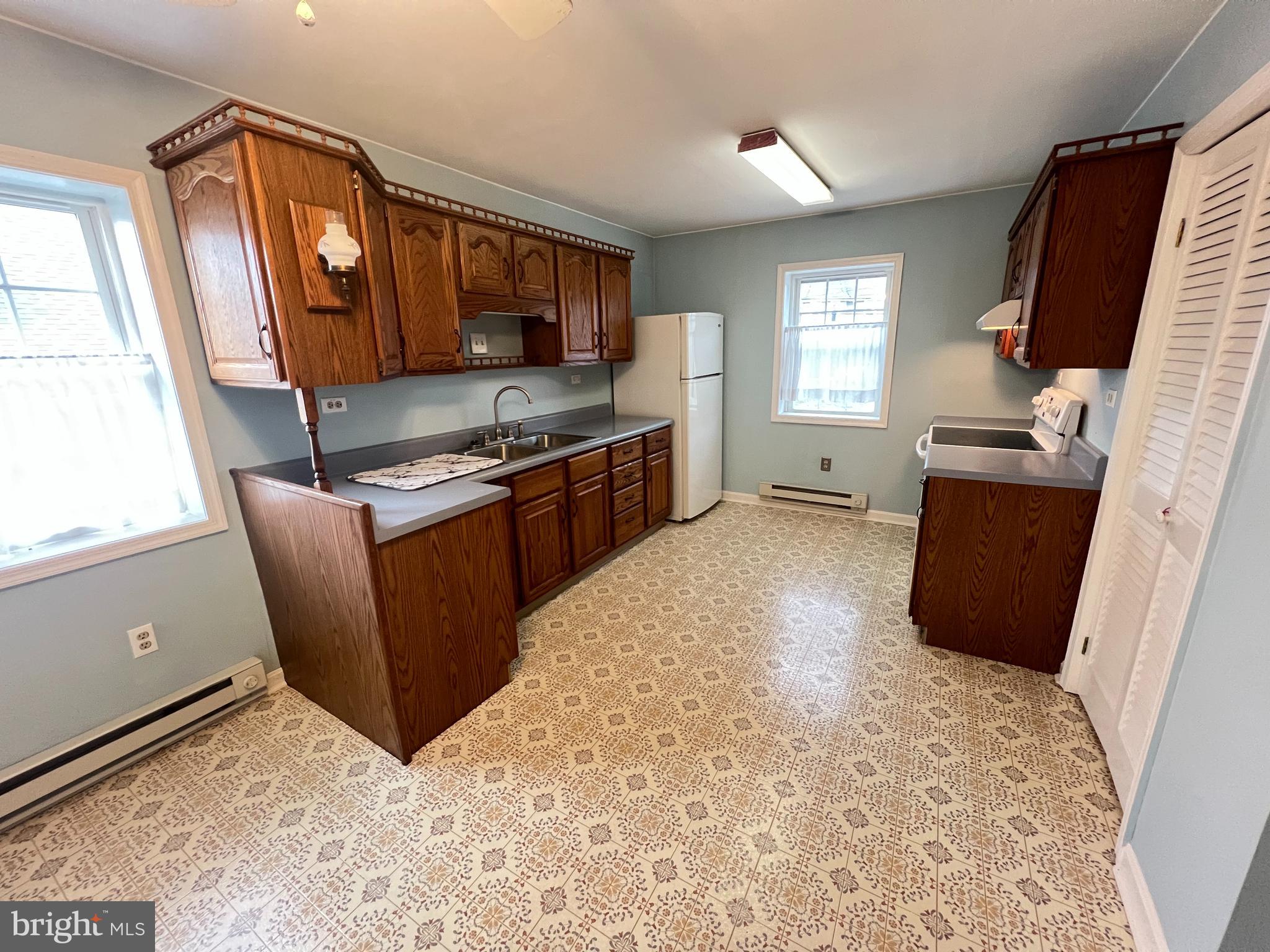 a kitchen with granite countertop a refrigerator stove top oven and sink