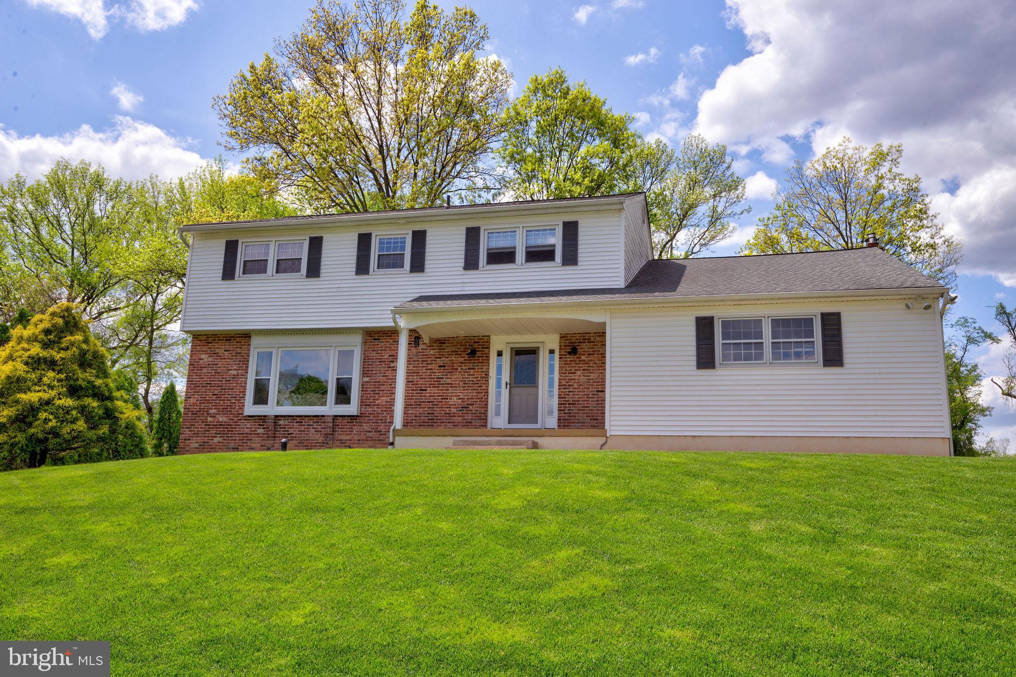 a front view of a house with a yard and trees