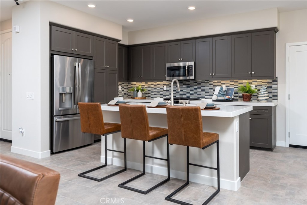 a kitchen with a dining table chairs refrigerator and cabinets