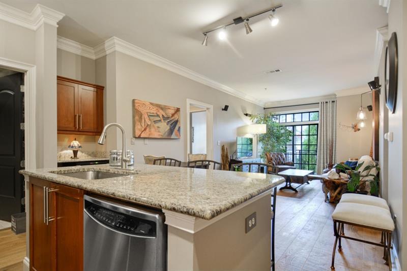 a view of center kitchen island a sink a refrigerator and chairs