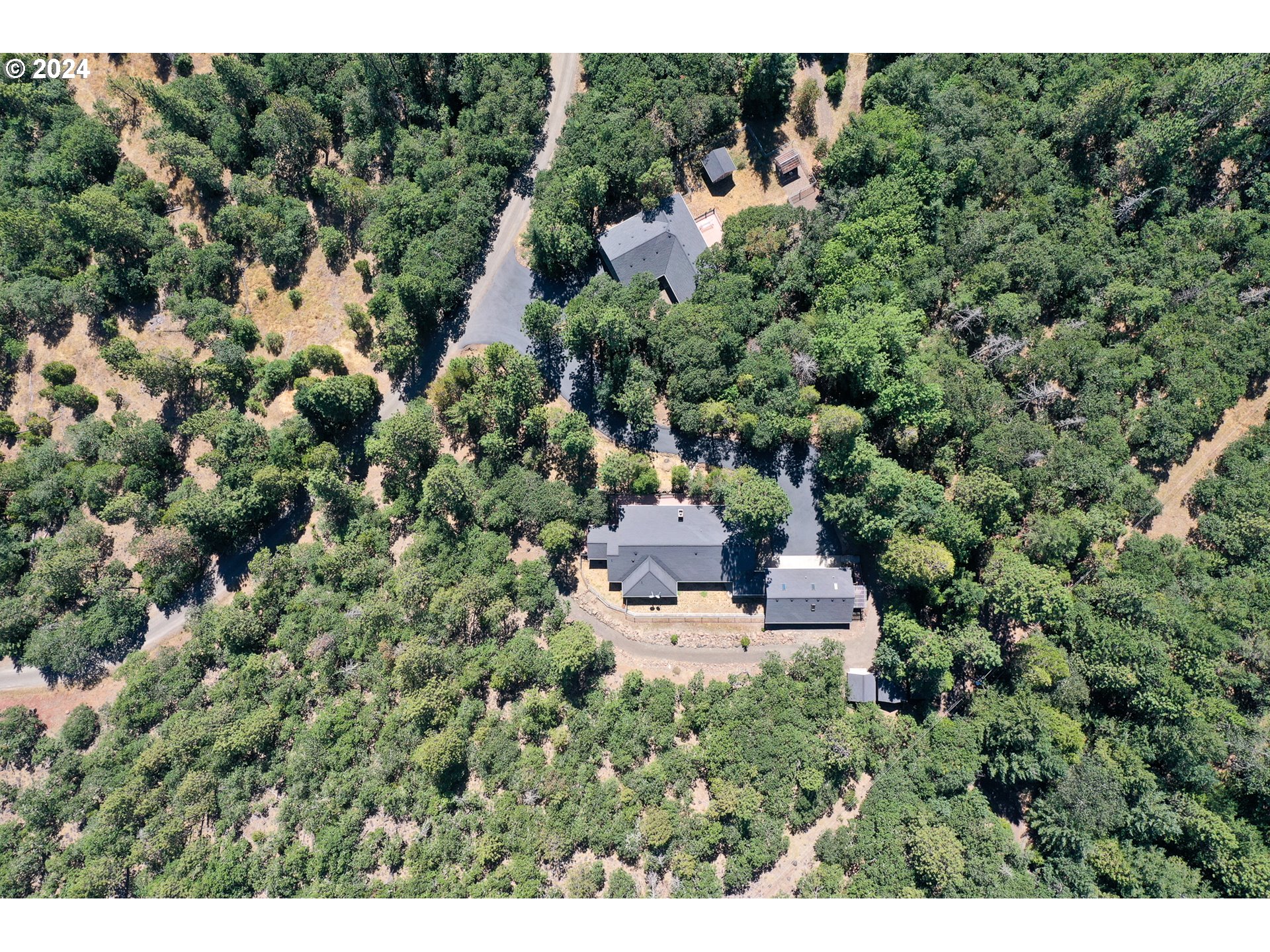 a view of a house with a lush green forest