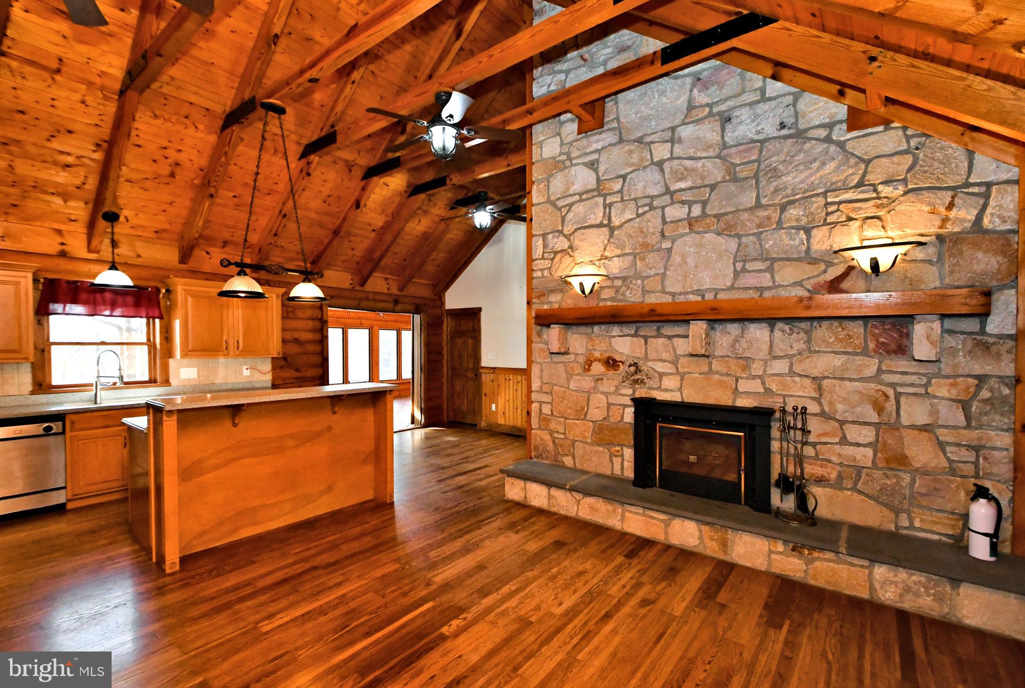 a living room with stainless steel appliances wooden floors and fireplace