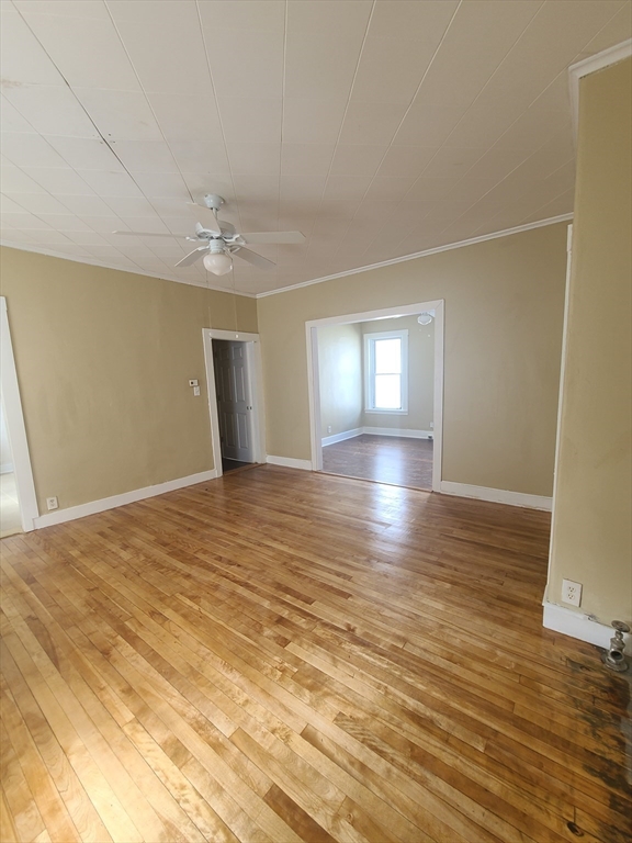 a view of empty room with wooden floor