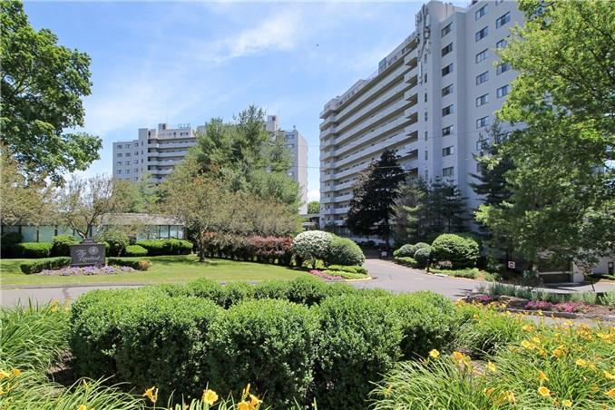 a view of a garden with tall buildings