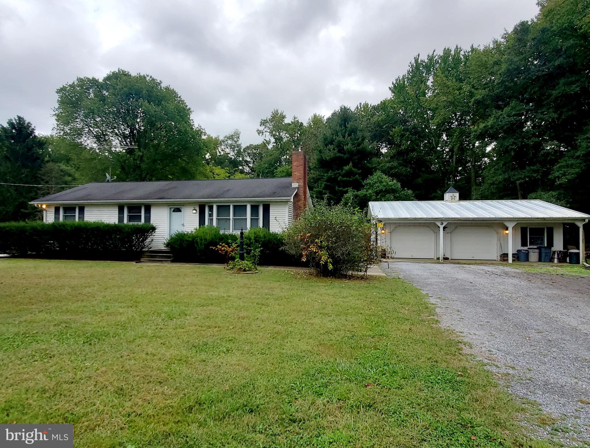 a front view of a house with a yard and trees