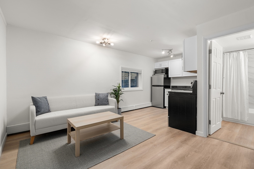 a living room with furniture and kitchen