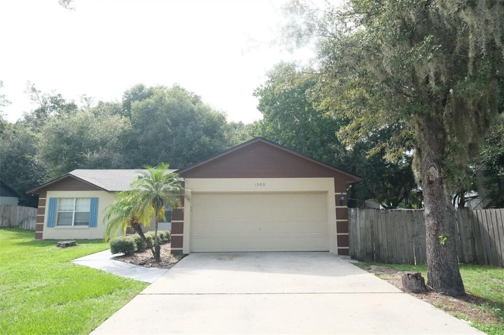 a front view of a house with a yard and trees