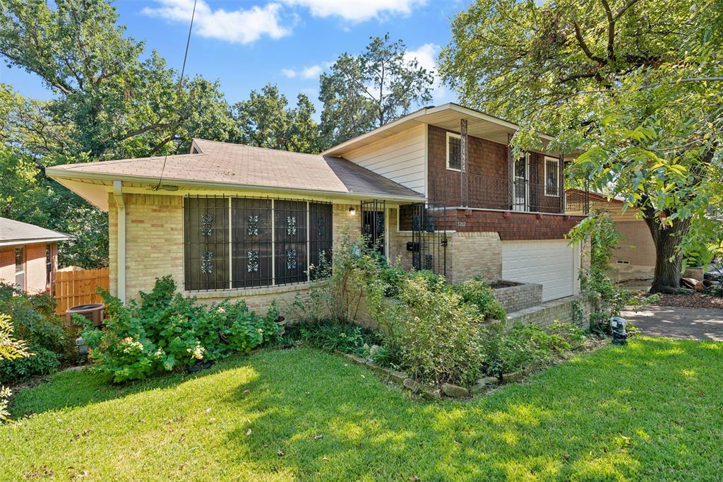 a front view of a house with a yard and trees