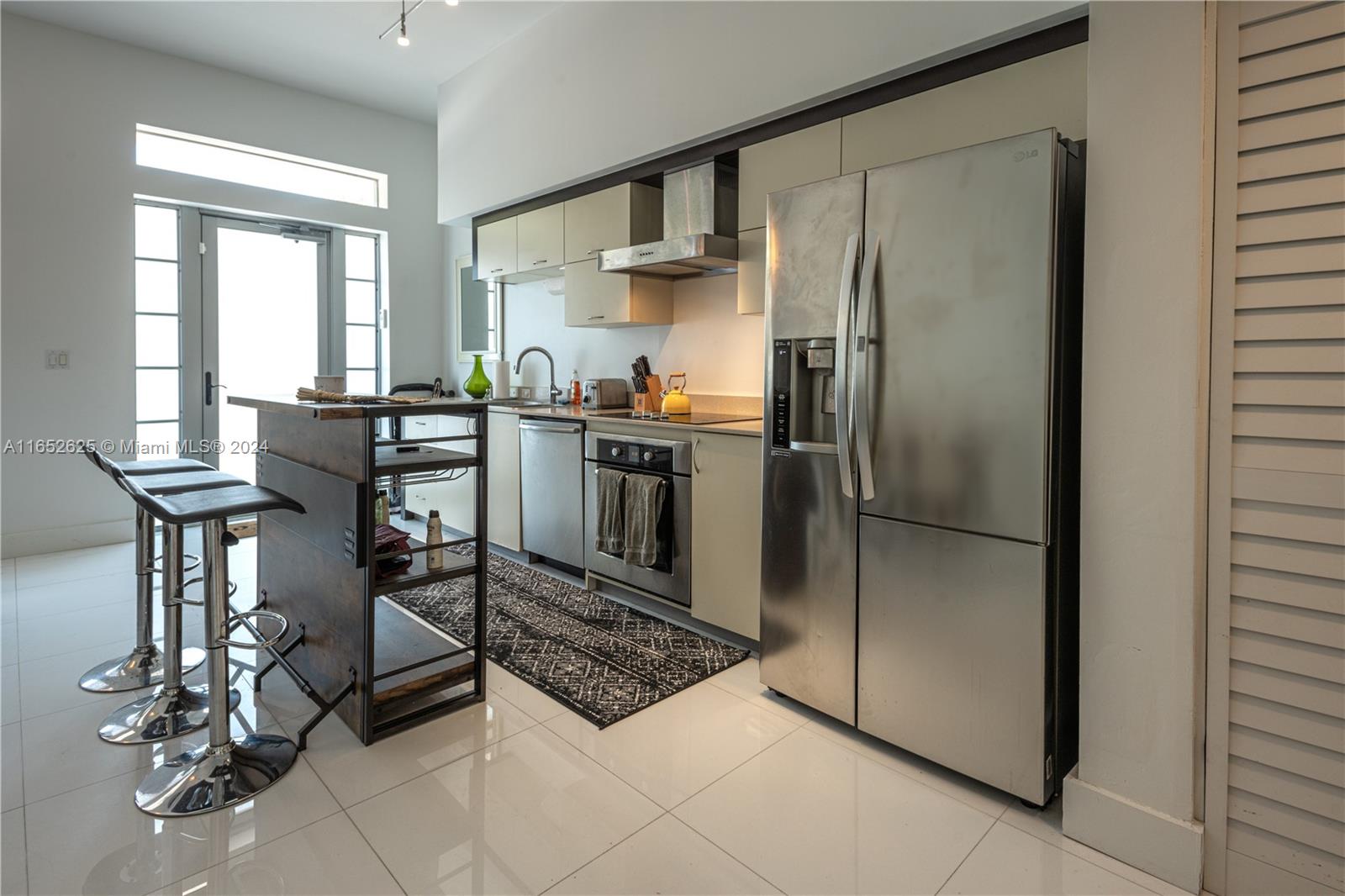 a kitchen with stainless steel appliances granite countertop a refrigerator and a stove top oven