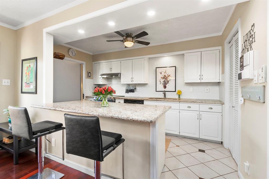 a kitchen with granite countertop sink window and white cabinets