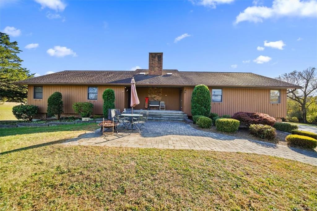 a view of a house with backyard and sitting area