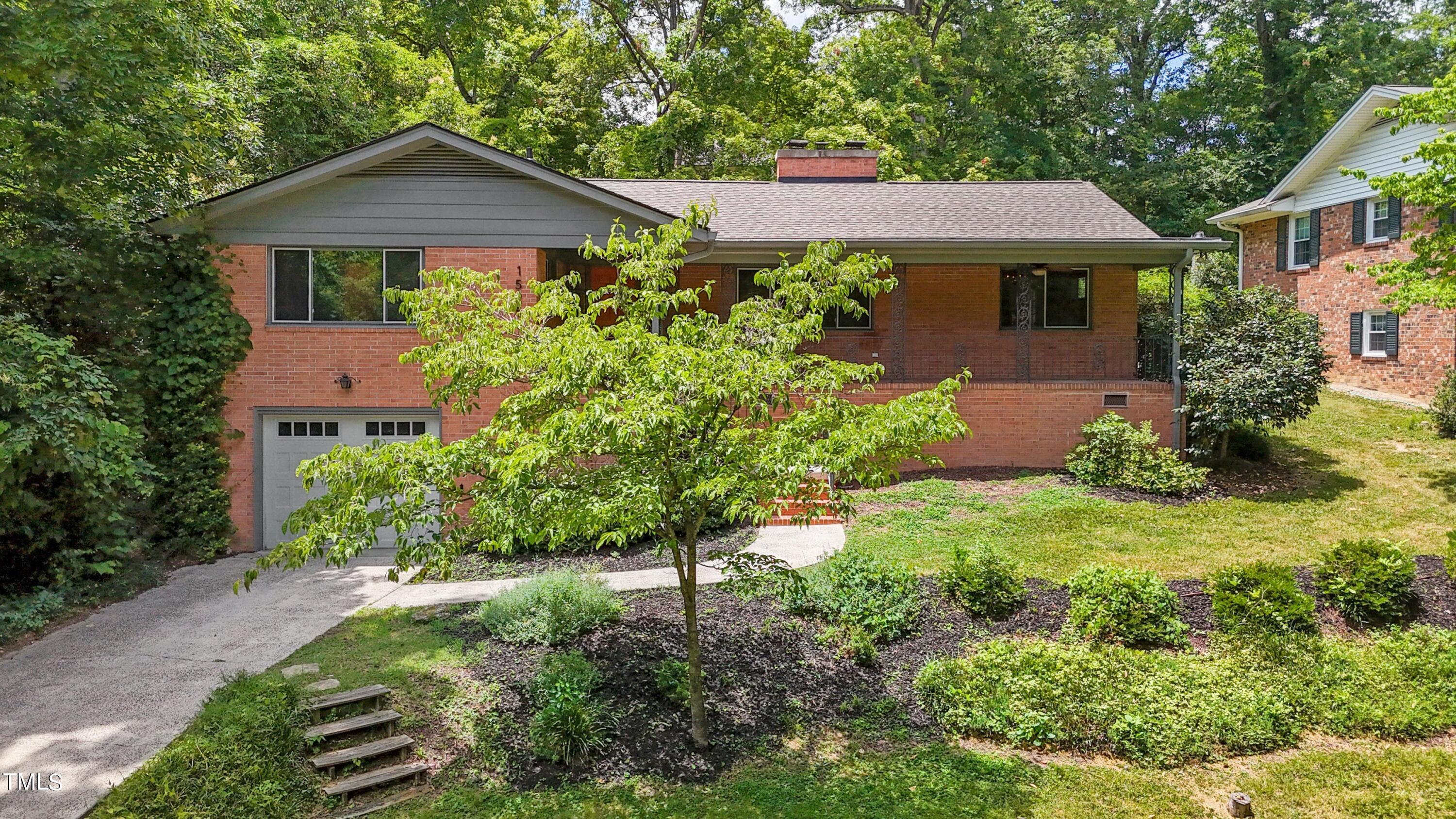 a front view of a house with a yard and trees