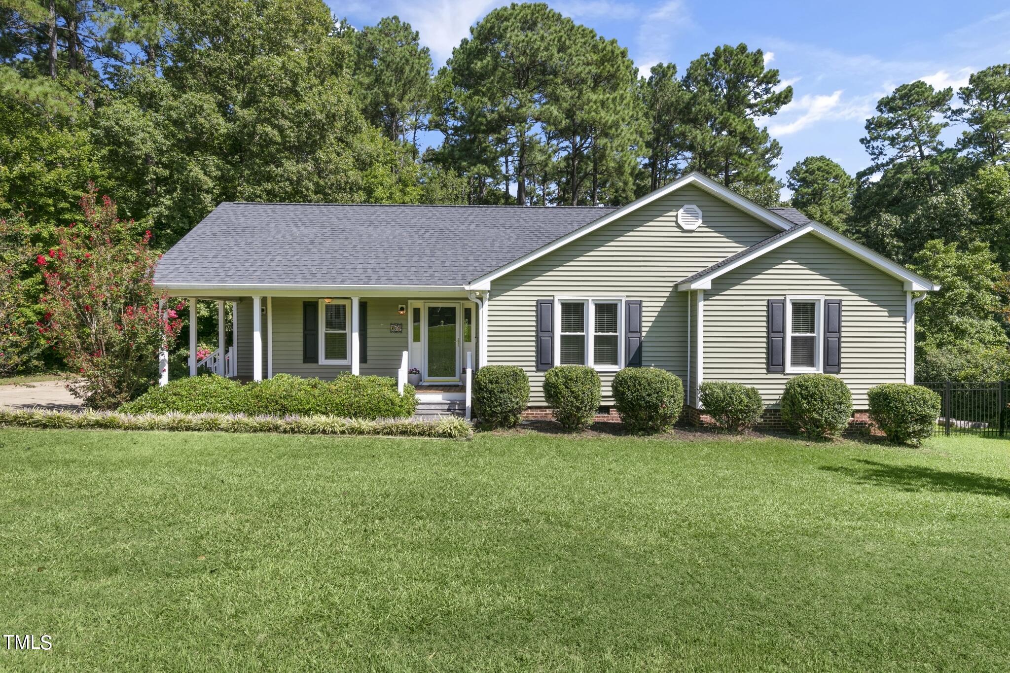 a front view of a house with a yard and green space